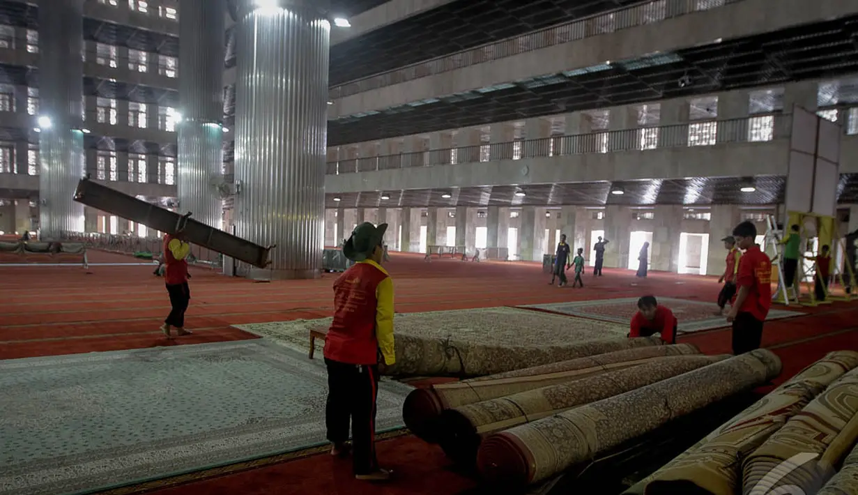 Petugas memasang karpet di ruang utama Masjid Istiqlal, Jakarta, Sabtu (4/10/14). (Liputan6.com/Faizal Fanani)