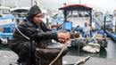 Seorang nelayan mengamankan perahunya saat Topan Kong-rey mendekati Taiwan, di wilayah Yilan pada 30 Oktober 2024. (I-Hwa CHENG/AFP)
