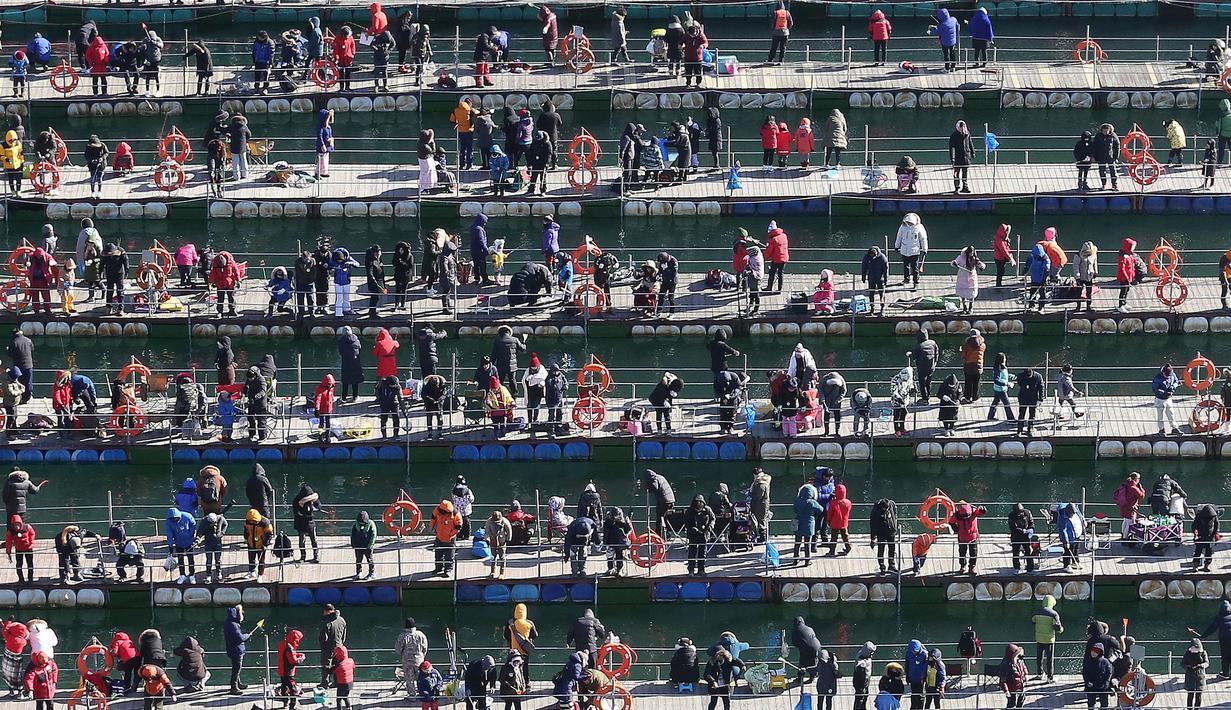 Suasana lomba menangkap ikan saat acara Festival Es di sungai Hwacheon yang membeku di Korea Selatan, Sabtu (14/1). (AP Photo/Ahn Young-joon)