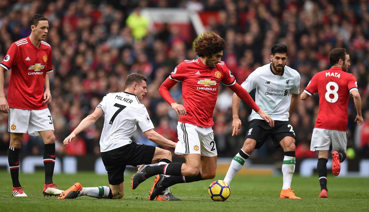 Gelandang Manchester United, Marouane Fellaini dijatuhkan gelandang Liverpool, James Milner pada laga Premier League di Stadion Old Trafford, Manchester, Sabtu (10/3/2018). MU menang 2-1 atas Liverpool. (AFP/Oli Scarff)