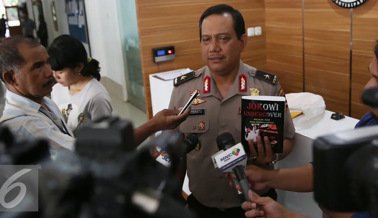 Kabagpenum Polri Brigjen Rikwanto menunjukkan buku Jokowi Undercover saat memberikan keterangan pers di Kadivhumas Polri, Jakarta, Selasa (3/1). (Liputan6.com/Johan Tallo)
