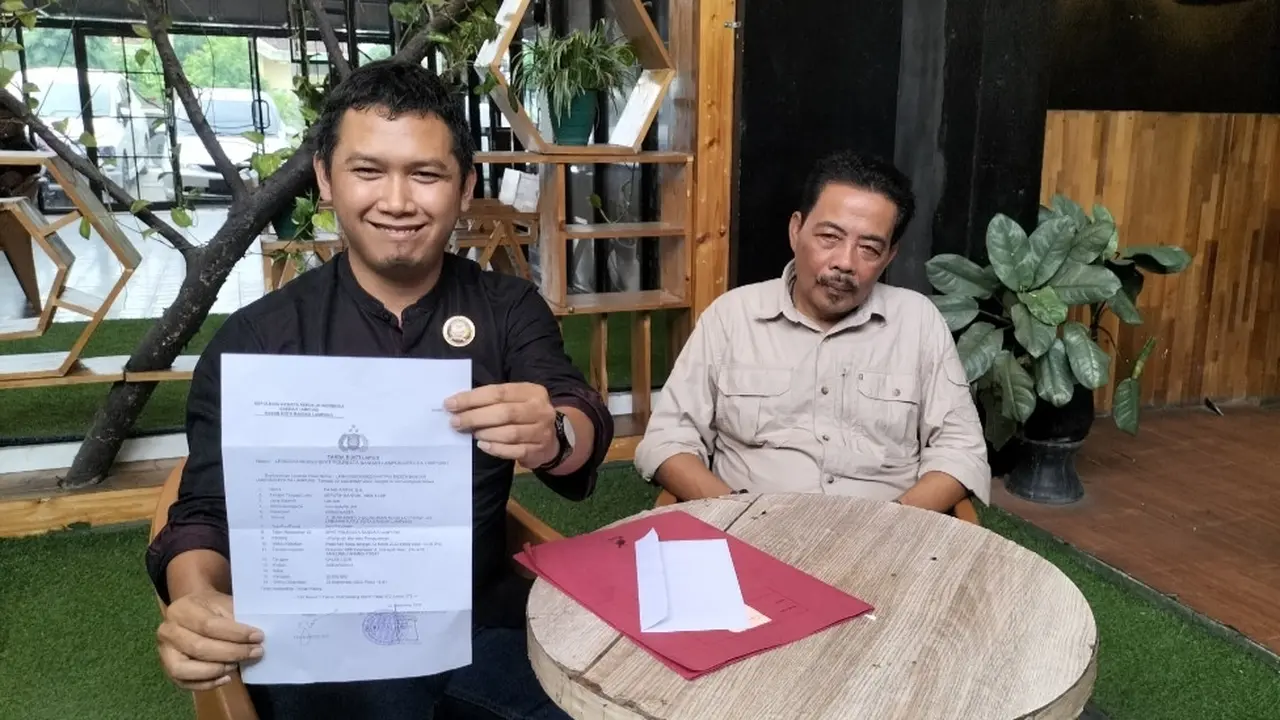 Fajar Arifin (kemeja hitam) mendampingi kliennya membuat laporan