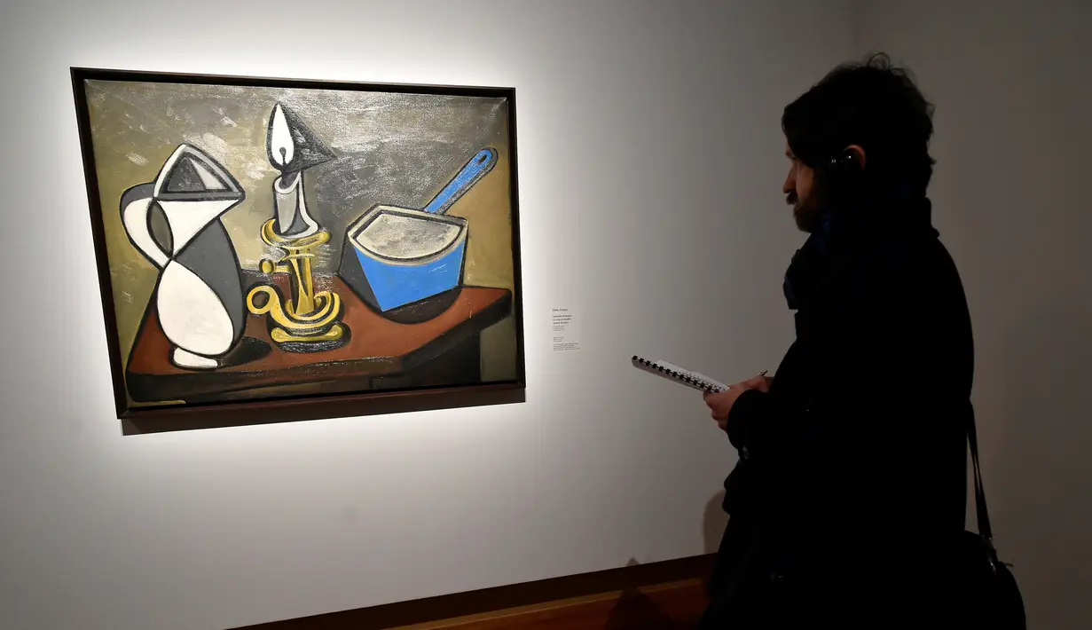 Seorang pengunjung melihat lukisan Jug, Candle and Enamel Pan (1945) karya pelukis Spanyol Pablo Picasso (1881-1973) saat pameran 'Spanish Still Life' di Pusat Seni Rupa BOZAR, Brussels, Belgia, Jumat (22/2). (AFP PHOTO/JOHN THYS)