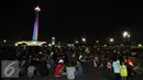 Pengunjung duduk duduk di halaman Monumen Nasional, Jakarta, Sabtu (31/12). Meski panggung hiburan malam pergantian tahun dibatalkan namun pengunjung tetap memadati kawasan Monumen Nasional . (Liputan6.com/Helmi Fithriansyah)