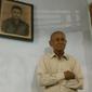 Mantan Anggota Cakrabirawa, Ishak, berfoto dengan latar belakang lukisan saat masih aktif berdinas. Ia masih gagah di usianya yang ke 81 tahun. (Liputan6.com/Muhamad Ridlo)