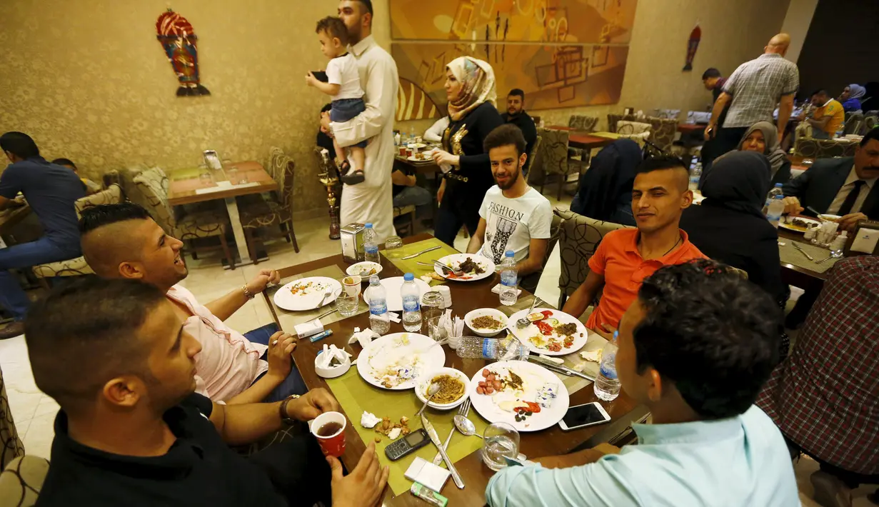 Sejumlah kafe di Irak mulai ramai dikunjungi saat waktu sahur oleh sejumlah warga, Irak, Kamis (9/7/2015). Setelah hampir 10 tahun tak boleh keluar malam, kini warga Irak bisa sahur bersama di Kafe. (Reuters Thaier Al-Sudani)
