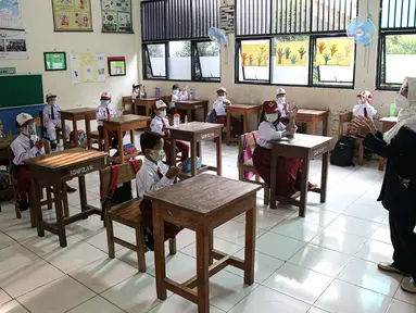 Guru memberikan materi pelajaran saat hari pertama uji coba pembelajaran tatap muka di SD Negeri 14 Pondok Labu, Jakarta, Senin (30/8/2021). Pemprov DKI melalui Dinas Pendidikan Provinsi DKI Jakarta memberlakukan sekolah tatap muka terbatas tahap 1 sebanyak 610 sekolah. (Liputan6.com/Faizal Fanani)