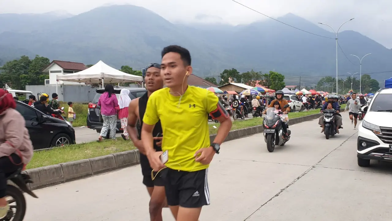 Berlatar view indah Gunung Guntur Garut, beberapa warga tengah melakukan lari sore sementara warga lainnya nampak menikmati ngabuburit di jalan Letjen (Purn) Ibrahim Adjie Garut. (Liputan6.com/Jayadi Supriadin)