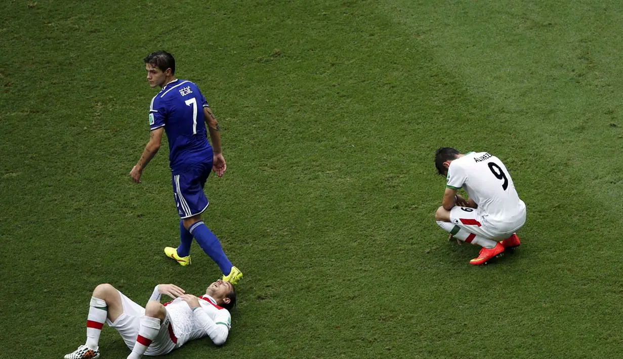 Dua pemain Iran tergeletak usai dikalahkan Bosnia 1-3 di laga penutup penyisihan Piala Dunia 2014 Grup F di Stadion Fonte Nova, Salvador, Brasil, (25/6/2014). (REUTERS/Fabrizio Bensch)