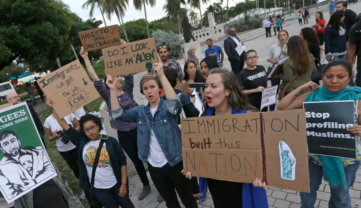 Pengunjuk rasa berkumpul di pusat kota Miami, AS, Kamis (26/1). Pengunjuk rasa menolak kebijakan Presiden AS, Donald Trump yang membatasi warga Muslim masuk ke AS. (AP Photo / Alan Diaz)