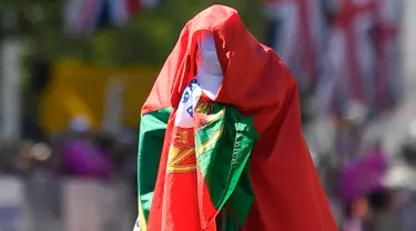 Pelari putri asal Portugal, Ines Henriques menutup tubuhnya dengan bendera negaranya setelah memenangkan medali emas dalam lomba lari putri selama Kejuaraan Atletik Dunia di London, Inggris (13/8). (AP Photo / Martin Meissner)