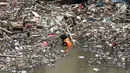 Petugas kebersihan Pemprov DKI membersihkan sampah yang terbawa arus di Pintu air Manggarai, Jakarta, Senin (2/10). Kegiatan ini guna mengurangi penumpukan sampah dan  mencegah datangnya banjir saat hujan deras di wilayah itu. (Liputan6.com/Johan Tallo)