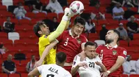 Kiper Timnas Irak, Jalal Hassan (kiri) berusaha menghalau bola dari ancaman bek Timnas Indonesia, Elkan Baggott (tengah) pada laga pertama Grup D Piala Asia 2023 Qatar di Ahmad bin Ali Stadium, Al-Rayyan, Doha, Senin (15/1/2024). (AFP/Karim Jaafar)