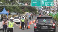 Petugas gabungan melakukan pengalihan arus lalu lintas di pos pemerikasan Ganjil Genap kawasan Gadog, Bogor, Jawa Barat, Sabtu (18/12/2021). Di masa libur Natal dan tahun baru 2022, Pemkab dan Polres Bogor berencana melakukan sistem ganjil genap di kawasan Puncak. (Liputan6.com/Herman Zakharia)