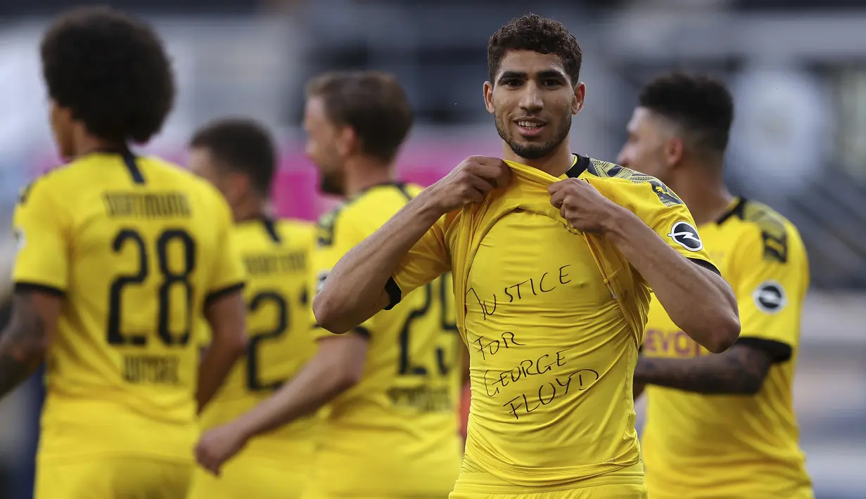 Pemain Borussia Dortmund, Achraf Hakimi, menunjukan tulisan rasa simpati untuk mendiang George Floyd saat melawan SC Paderborn 07 pada laga Bundesliga di Stadion Benteler, Minggu (31/5/2020). Borussia Dortmund menang dengan skor 6-1 SC Paderborn 07. (AP/Lars Baron)