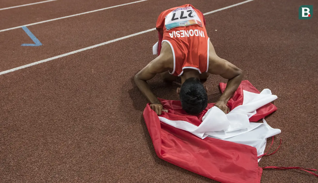Pelari Indonesia, Sapto Yogo Purnomo, melakukan sujud usai meraih medali emas cabang atletik nomor lari 200 meter T 37 Asian Para Games di SUGBK, Jakarta, Senin (8/10/2018). (Bola.com/Vitalis Yogi Trisna)