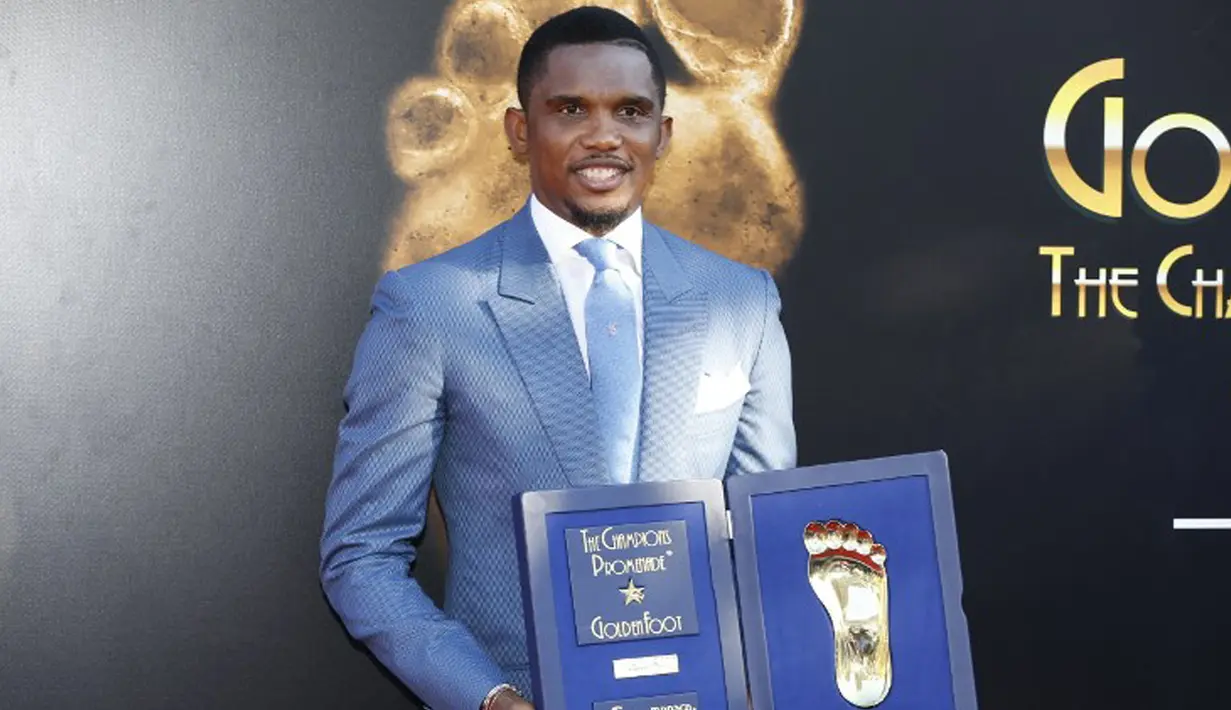 Pemain Kamerun, Samuel Eto'o berpose dengan trofi Golden Foot miliknya, Monaco, Senin (21/9/2015). Golden Foot 2015 diraih lima orang yaitu Rinat Dasaev, Daniel Passarella, Gheorghe Hagi,  Trezeguet dan Eto'o. (AFP Photo/Valery Hache)