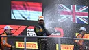 Pembalap Ferrari, Charles Leclerc merayakan kemenangan dengan menyemprotkan sampanye saat Formula 1 GP Italia 2024 yang berlangsung di Sirkuit Monza, Italia, Minggu (01/09/2024). (AFP/Gabriel Bouys)