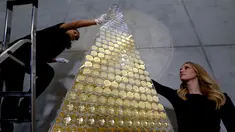 Karyawan rumah emas ProAurum menyusun koin emas yang disebut sebagai pohon Natal di Munich, Jerman, 3 Desember 2018. Pohon Natal ini terbuat dari 2.018 koin emas filharmonik wina senilai 2.3 euro atau sekitar 370 milliar rupiah. (AP/Matthias Schrader)