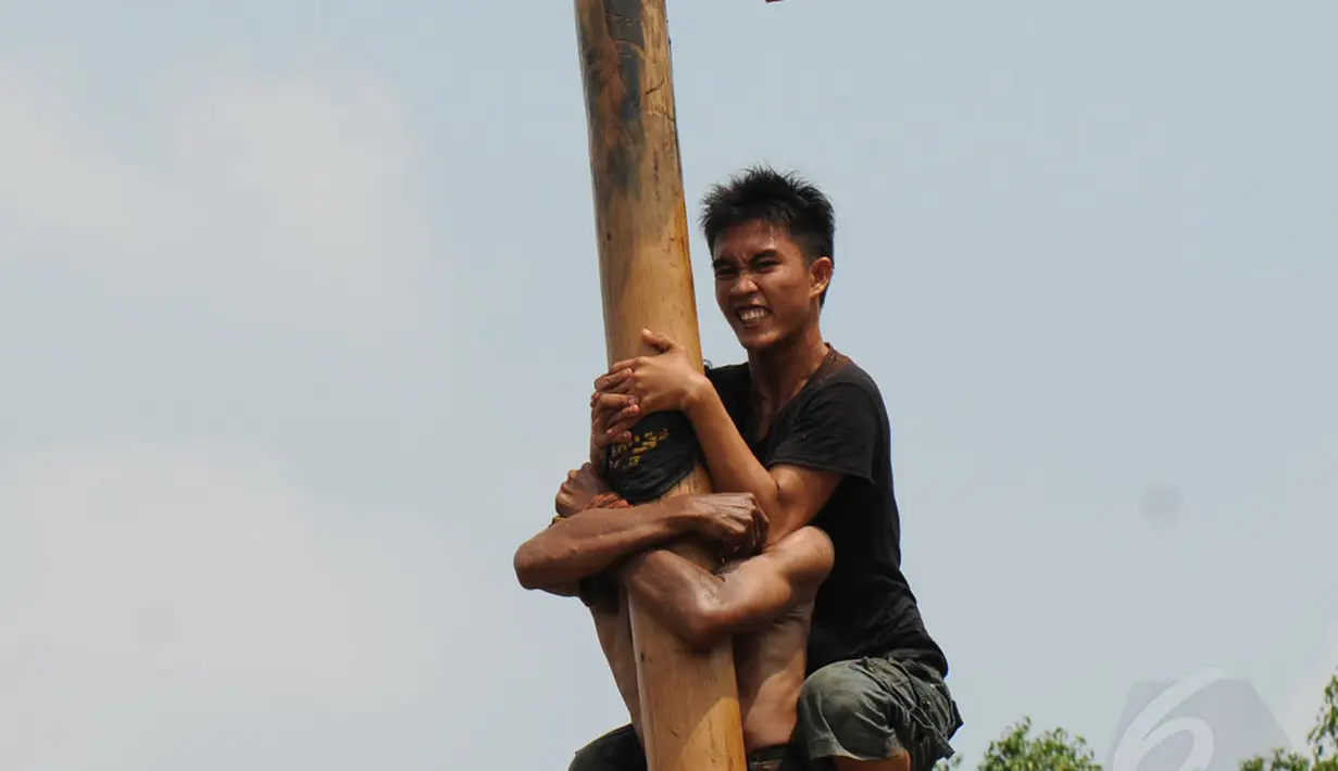 Ekpresi salah satu peserta lomba panjat pinang dalam rangka memeriahkan HUT RI ke-69 di kawasan Tugu Monas, Jakarta, (31/8/2014). (Liputan6.com/Helmi Fithriansyah)