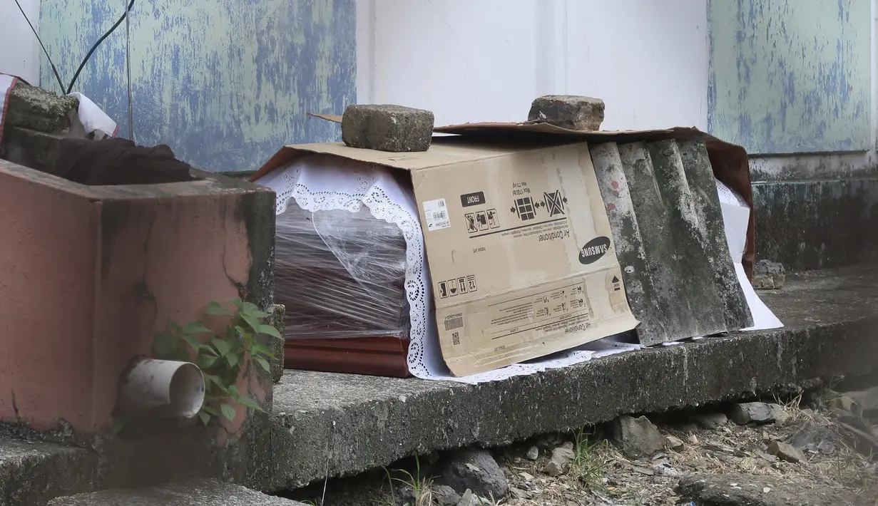 Peti mati berisi jenazah yang diduga meninggal karena virus corona COVID-19 terlihat di luar blok apartemen di Guayaquil, Ekuador, Kamis (2/4/2020). Rumah sakit dan rumah duka di Guayaquil begitu kewalahan dengan gelombang pasien maupun korban meninggal yang bertambah. (AP Photo/Filiberto Faustos)