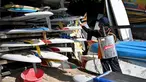 Petugas kesehatan menyemprotkan disinfektan pada papan selancar di sepanjang pantai kawasan wisata Sanur, Bali, Senin (16/3/2020). Penyemprotan dilakukan sebagai salah satu langkah untuk mengantisipasi potensi penyebaran virus Corona COVID-19 di kawasan pariwisata tersebut. (SONNY TUMBELAKA/AFP)