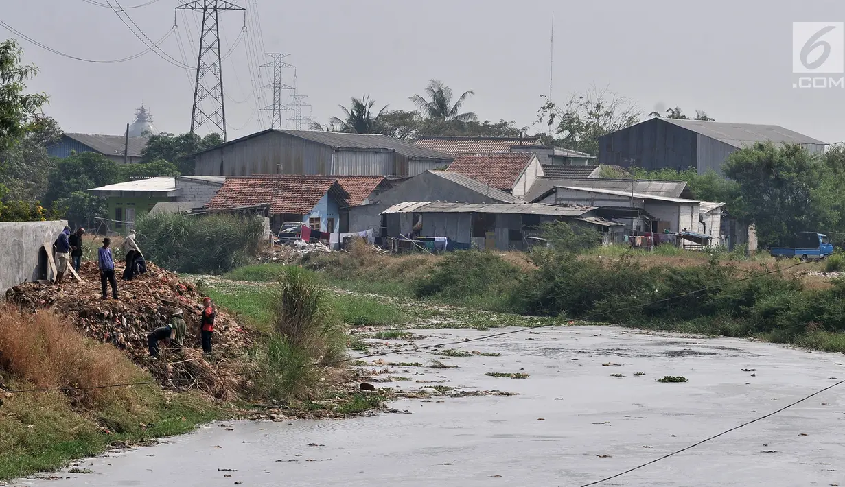 Pekerja beraktivitas di pinggir Kali Pisang Batu, Desa Setia Asih, Tarumajaya, Kabupaten Bekasi, Jawa Barat, Minggu (29/7/2019). Kali Pisang Batu kembali dipenuhi limbah pabrik dan sampah rumah tangga setelah sempat dikeruk pada Januari lalu. (merdeka.com/Iqbal Nugroho)