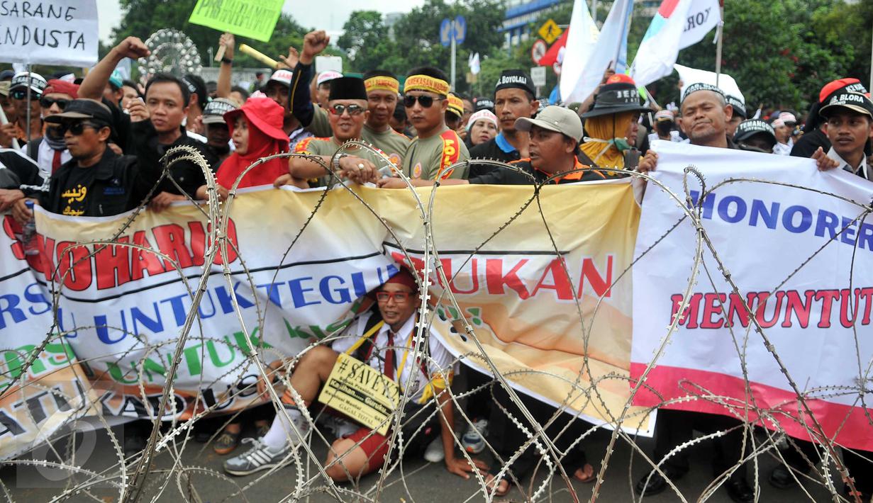Massa dari Forum Honorer Kategori 2 (FHK2I) membentangkan spanduk saat unjuk rasa di depan Istana Merdeka, Jakarta, Rabu (10/2). Guru honorer dari seluruh Indonesia itu menuntut Pemerintah agar mengangkat mereka sebagai PNS. (Liputan6.com/Gempur M Surya)