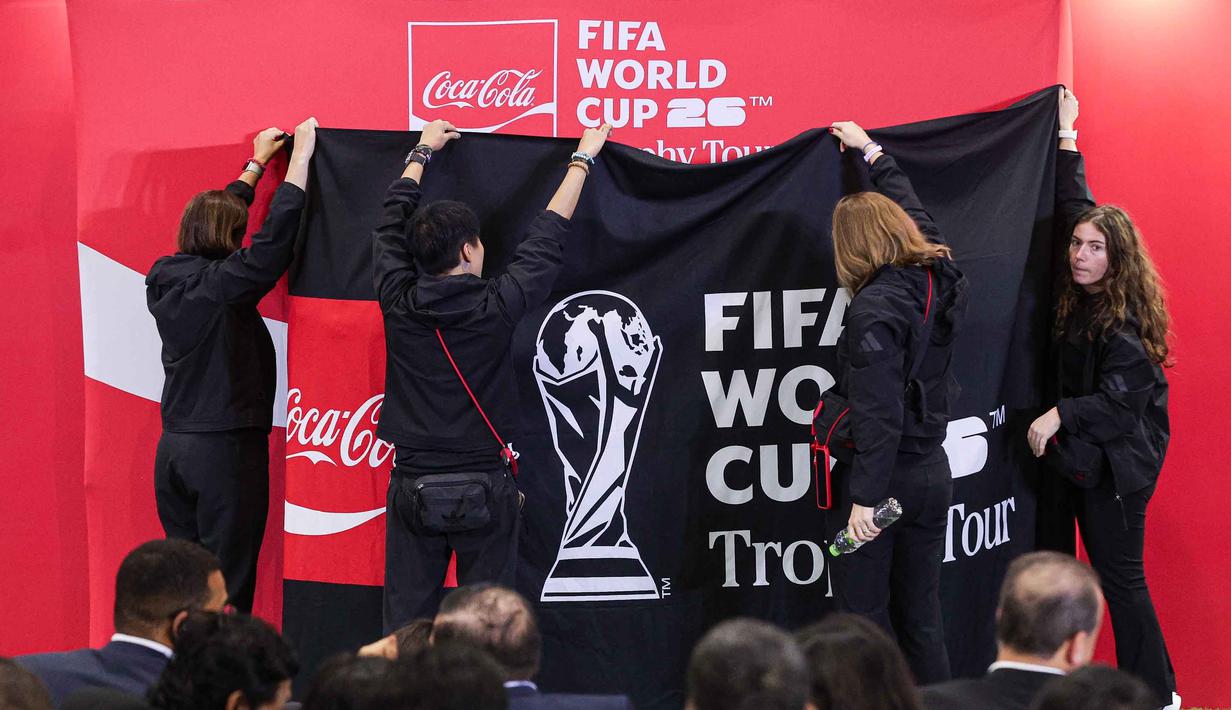 Hal ini dikarenakan, piala tertinggi kompetisi sepak bola dunia tersebut sedang mampir ke Jakarta Convention Center (JCC) dalam rangkaian acara Coca Cola FIFA World Cup Trophy Tour pada Kamis (22/1/2026). Tampak dalam foto, penyelenggara membuka selubung penutup trofi original Piala Dunia terpajang saat gelaran FIFA World Cup Trophy Tour by Coca-Cola di Jakarta International Convention Center (JICC), Senayan, Jakarta, Kamis (22/1/2026). (Bola.com/Abdul Aziz)