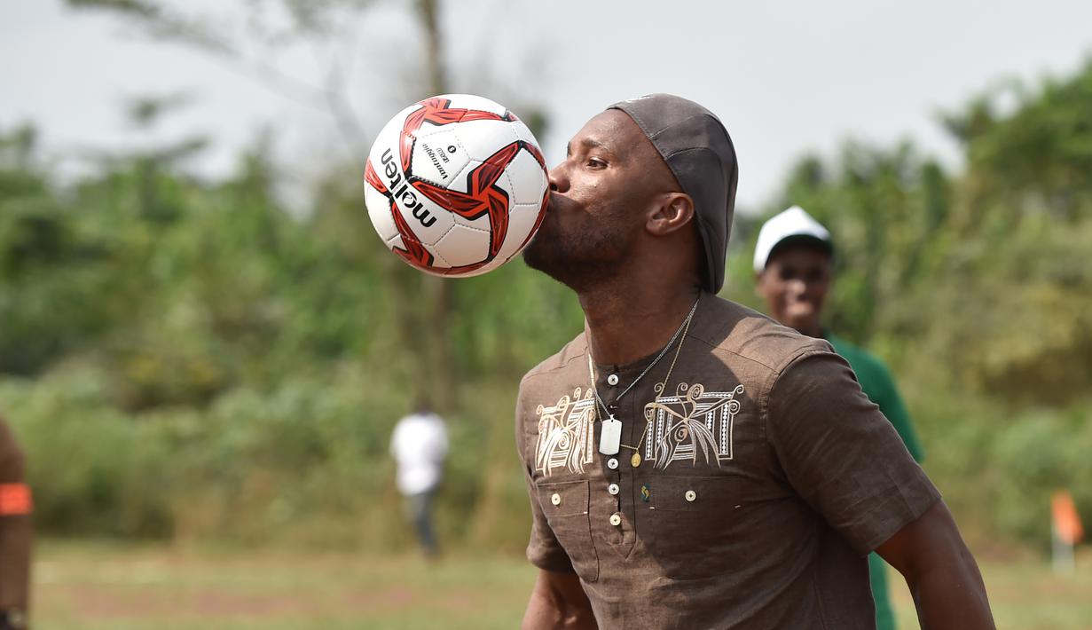 Mantan penyerang Chelsea, Didier Drogba menunjukan skil dalam mgnolah bola saat membuka sekolah dasar di Onahio, Pokou-Kouamekro, Pantai Gading, (20/1/2018).  Drogba menjadi salah satu sponsor utama untuk sekolah tersebut. (AFP/Sia Kambou)