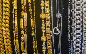 Sementara, untuk harga emas perhiasan berdasarkan data dari Raja Emas Indonesia, Laku Emas, dan Hartadinata Abadi dalam berbagai kadar karat pada Rabu (14/1/2026) cenderung stabil, seperti harga emas perhiasan 24 Karat per gram diangka Rp 2.300.000. Tampak dalam foto, perhiasan emas dipajang di sebuah toko perhiasan di Banda Aceh pada Rabu 14 Januari 2026. (CHAIDEER MAHYUDDIN/AFP)