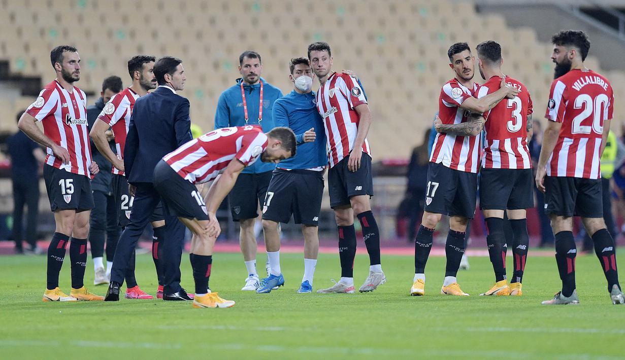 Para pemain Athletic Bilbao tampak lesu usai ditaklukkan Barcelona pada laga final Copa del Rey di Stadion Olimpico de Sevilla, Minggu (18/4/2021). Barcelona menang 4-0 atas Athletic Bilbao. (AFP/Cristina Quicler)
