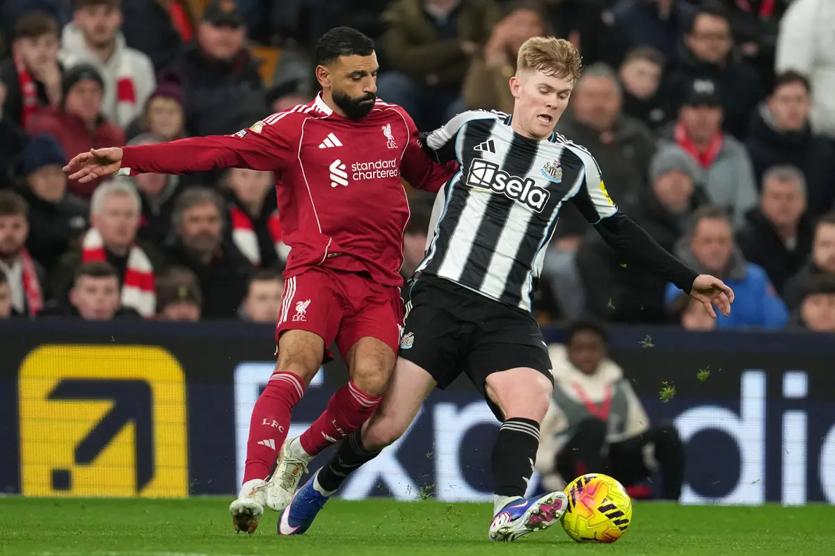 Bintang Liverpool Mohamed Salah (kiri) berebut bola dengan bek Newcastle Lewis Hall di laga pekan ke-24 Liga Inggris 2025/2026 di Anfield, Minggu (01/02/2026) dini hari WIB.