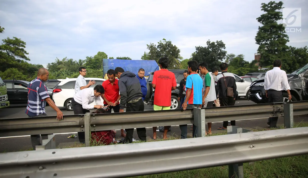 Pengendara membantu korban kecelakaan antara mobil Toyota Fortuner dengan truk boks Colt Diesel di tol Jagorawi, Kamis (28/12). Kecelakaan tersebut terjadi tepatnya di KM 23 arah Jakarta. (Liputan6.com/Angga Yuniar)