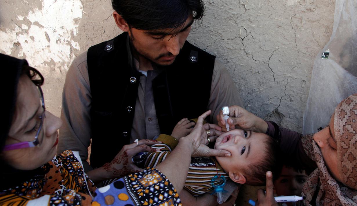 Petugas memberikan imunisasi polio di sepanjang jalan di Quetta, Pakistan, Senin (2/1). (REUTERS/Naseer Ahmed)