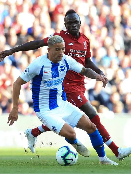 Striker Liverpool, Sadio Mane berusaha merebut bola yang dibawa gelandang Brighton and Hove Albion, Anthony Knockaert saat bertanding pada lanjutan Liga Inggris di Anfield Stadium (25/8). Liverpool menang atas Brighton 1-0. (AFP Photo/Lindsey Parnaby)