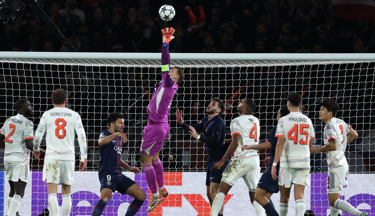 Pemain Bayern Munchen, Manuel Neuer (tengah) menghalau bola di depan gawangnya dalam laga Liga Champions 2025/2026 melawan PSG di Parc des Princes, Paris, Prancis, Selasa (04/11/2025) waktu setempat. (AFP/Franck Fife)
