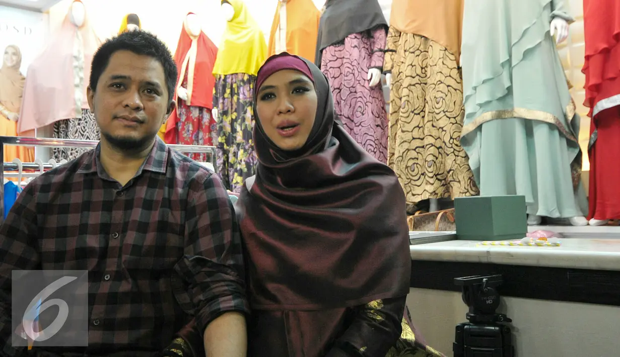 Oki Setiana Dewi bersama suami memberikan keterangan saat peresmian toko busana muslimnya yang ke-4 di Tanah Abang, Jakarta, Rabu (2/12). Memasuki kehamilan 7 bulan, Oki justru semakin aktif dengan membuka toko baju Muslimnya. (Liputan6.com/Yoppy Renato)