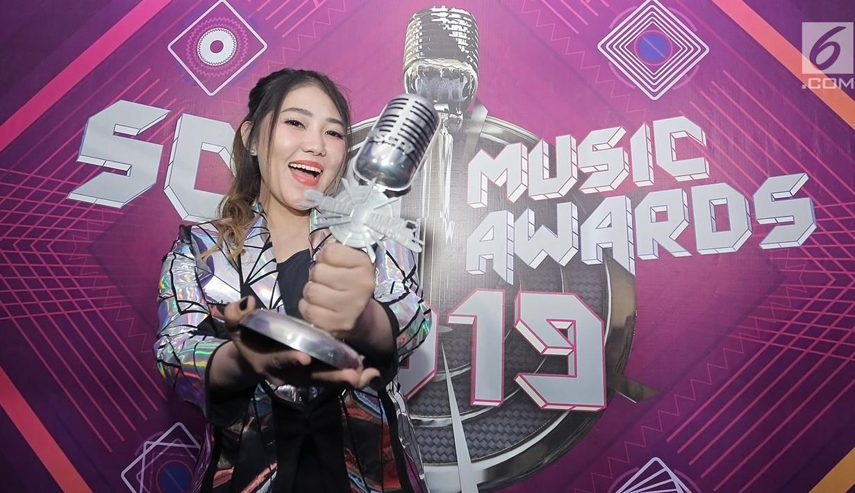 Penyanyi dangdut Via Vallen menunjukkan piala penghargaan usai acara SCTV Music Awards 2019 di Studio 6 Emtek City, Jakarta, Jumat (26/4). Via Vallen memboyong gelar Kategori Lagu Pop Paling Ngetop melalui "Meraih Bintang" yang sempat menjadi Theme Song Asian Games 2018. (Fimela.com/Bambang E. Ros)