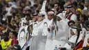 Penonton memegang sketsa Mesut Ozil di tribun selama pertandingan Spanyol vs Jerman pada laga Grup E Piala Dunia 2022  di Stadion Al Bayt, Kota Al Khor, Senin (28/11/2022) dini hari WIB. Aksi sindiran balik dari tribune Al-Bayt itu kemudian merujuk kepada tindakan rasialisme yang dilakukan Jerman kepada mantan pemainnya tersebut.  (AP Photo/Ebrahim Noroozi)