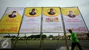 Seorang pekerja melintasi baliho Ade Komarudin di kawasan alun alun utara Yogyakarta, Jumat (11/3/2016). Ade Komarudin akan mendekalrasikan pencalonan ketua Umum DPP Golkar yang akan bertarung pada Munaslub 2016. (Liputan6.com/Boy Harjanto)