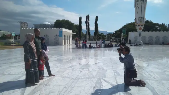 Pengunjung berfoto di pelataran Masjid Raya Baiturrahman (Liputan6.com/Rino Abonita)