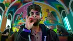 Anggota Gereja Ganja Internasional, Tushar Mallick mengisap ganja di Denver, Colorado, AS, Jumat (20/4). Aksi ini bertepatan dengan perayaan Hari Ganja Sedunia atau lebih dikenal dengan 4/20. (AFP PHOTO/Jason Connolly)