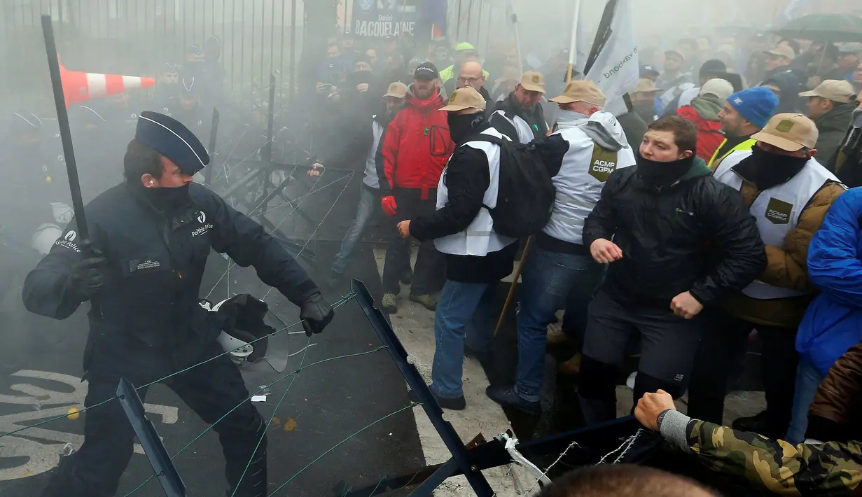 Polisi dan Demonstran terlibat bentrok saat aksi menolak Reformasi Pensiun di Brussels, Belgia, Selasa (15/11). Mereka menolak rencana pemerintah yang akan menaikkan usia pensiun dari 56 menjadi 63 tahun. (REUTERS / Yves Herman)