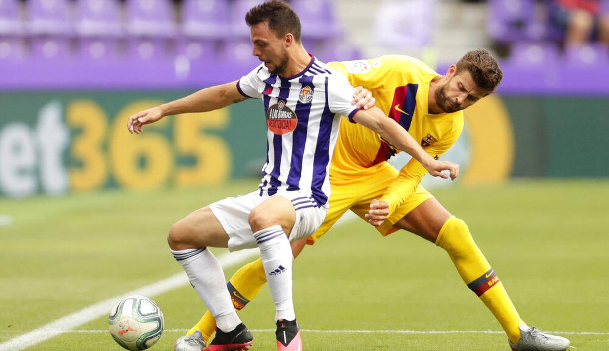 Bek Barcelona, Gerard Pique, berebut bola dengan pemain Real Valladolid, Oscar Plano, pada laga La Liga di Stadion Jose Zorrilla, Sabtu (11/7/2020). Barcelona menang 1-0 atas Real Valladolid. (AP Photo/Manu Fernandez)