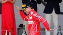 Pembalap Ferrari Sebastian Vettel berselebrasi di atas podium saat merayakan kemenangannya pada balapan GP Monaco di Sirkuit Monte Carlo, Minggu (28/5). Vettel finis pada urutan pertama dengan waktu satu jam 44 menit 44,340 detik (AP Photo/Frank Augstein)