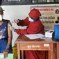 Petugas kesehatan dari Puskesmas Kecamatan Matraman melakukan vaksinasi COVID-19 di SD Negeri 25 Utan Kayu Selatan, Matraman, Jakarta Timur, Rabu (23/3/2022). Layanan vaksinasi digelar setiap hari Senin sampai Jumat pukul 08.00-11.00 WIB. (Liputan6.com/Herman Zakharia)