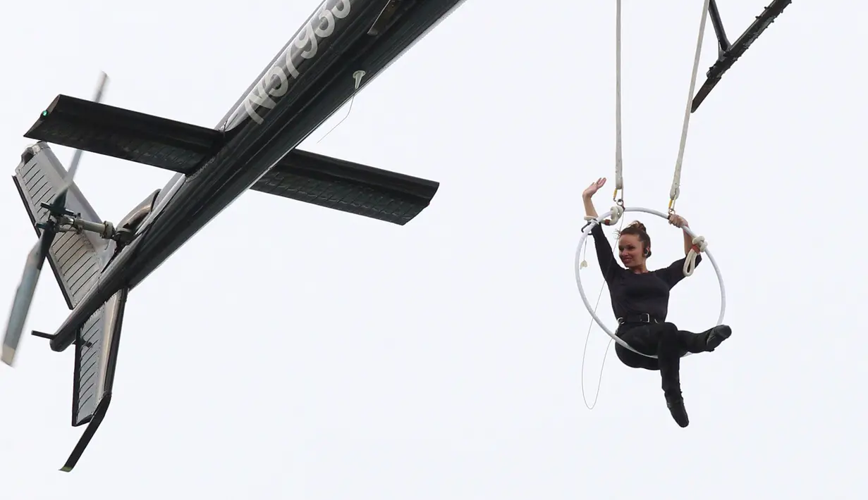 Akrobatis udara, Erendira Wallenda melambaikan tangan saat melakukan serangkaian aksi akrobatik di atas air terjun Niagara, New York, Kamis (15/6). Erendira bergelayutan di lingkaran besi yang dikaitkan pada sebuah helikopter. (AP Photo/Bill Wippert)