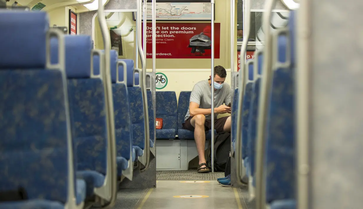 Seorang penumpang yang mengenakan masker menaiki kereta Go di Toronto, Kanada (21/7/2020). Mulai Selasa (21/7), para pelanggan layanan transportasi umum di Kanada, Go Transit, diwajibkan mengenakan masker atau penutup wajah. (Xinhua/Zou Zheng)