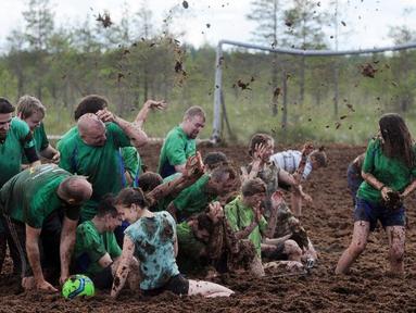 Pemain sepak bola rawa berebut bola dalam turnamen memperebutkan Piala Rusia yang berlangsung di Saint Petersburg, Rusia. Sabtu (27/6). (AFP PHOTO/OLGA MALTSEVA)